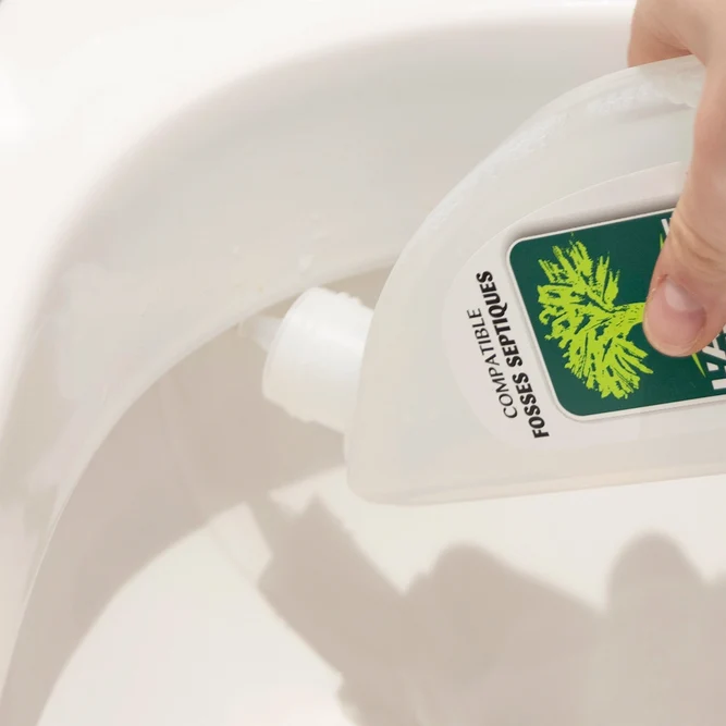 Une main appliquant du gel WC L'Arbre Vert sous les rebords de la cuvée des toilettes avec un flacon bec coudé.